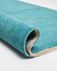 Close-up of vibrant turquoise over-dyed wool rug texture