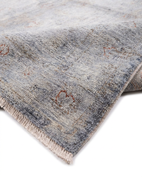 Grey-blue over-dyed wool rug folded diagonally to show pile texture