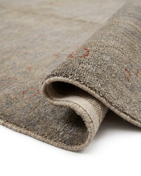 Close-up of grey-beige over-dyed wool rug faded floral medallion