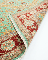 Super Kazak mint-green tribal wool rug folded to show pile and border detail