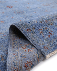 Cornflower blue over-dyed wool rug folded to show pile texture